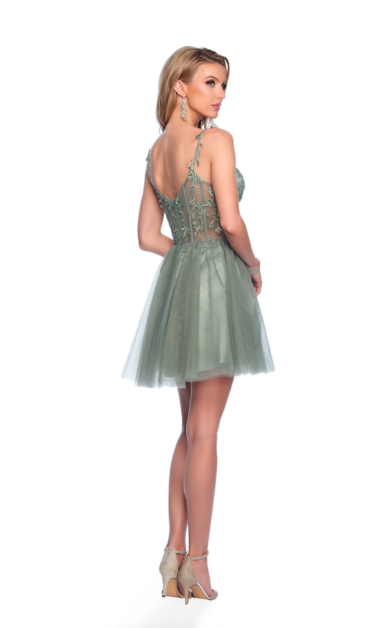 Woman wearing the Sage Green Homecoming Dress: Dave & Johnny 11920 featuring a corset bodice, lace details, and a tulle A-line skirt, posed in heels against a white background.